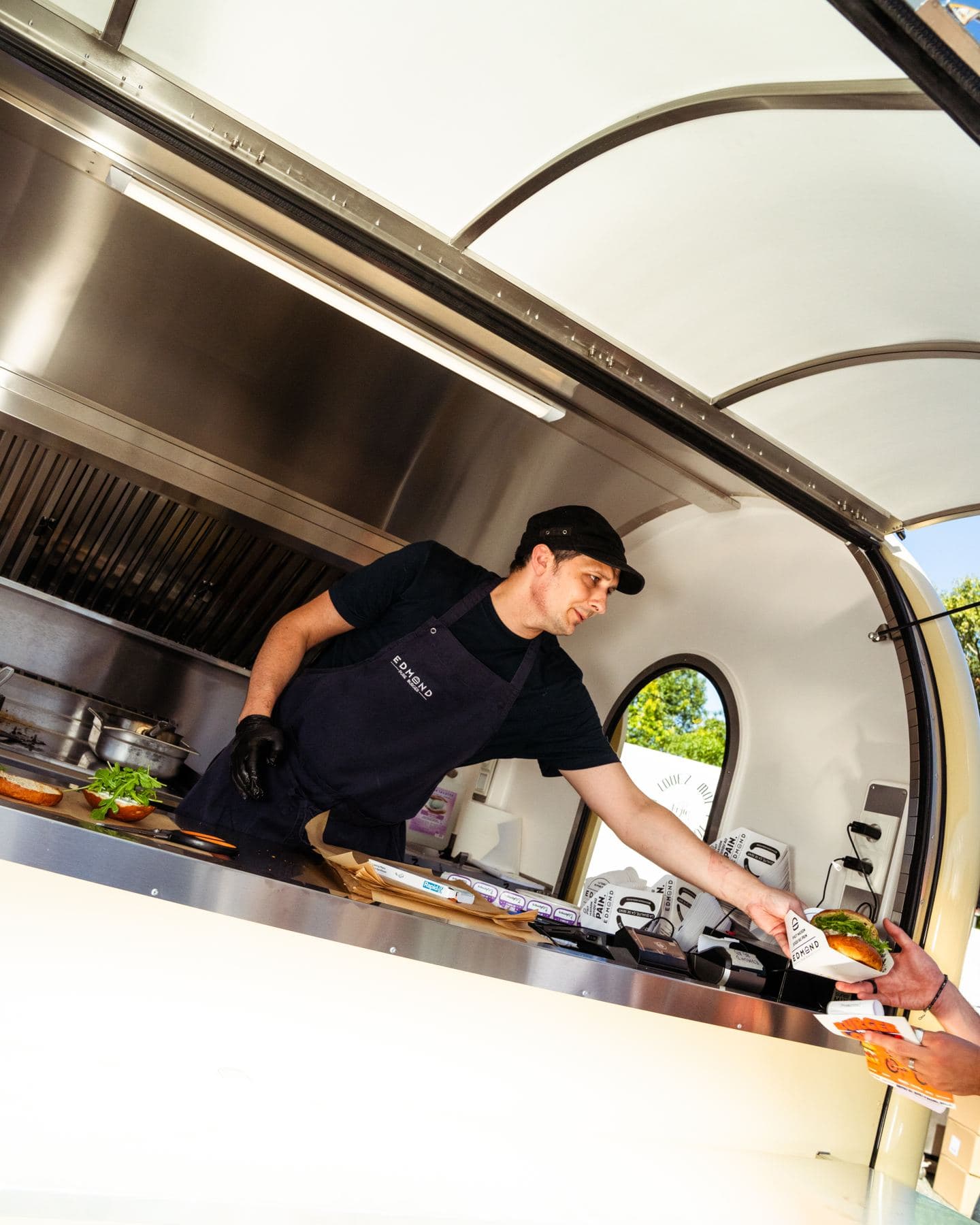 Un cuoco serve un cliente dal proprio rimorchio food truck