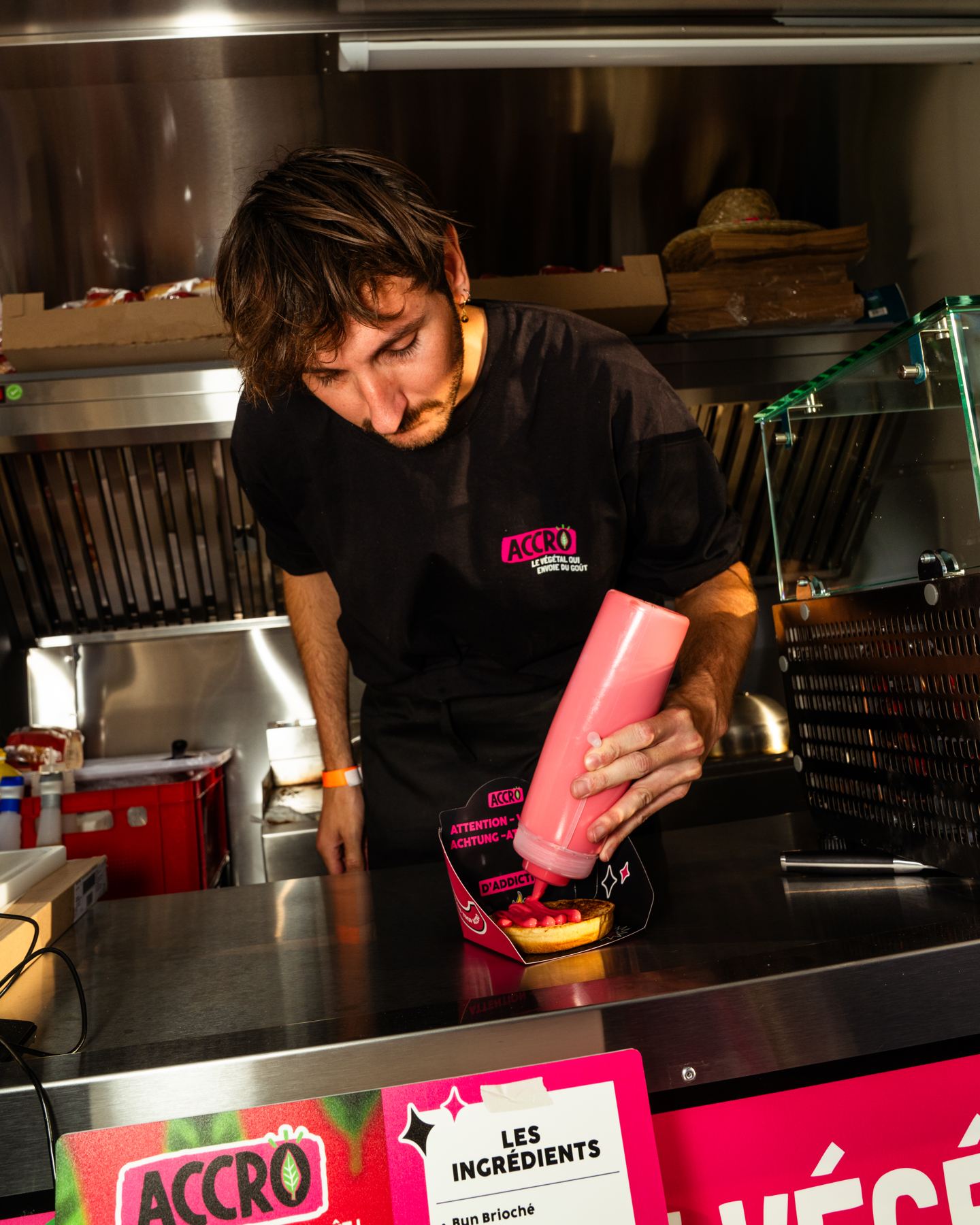 Salsa su un hamburger, sul piano di lavoro in acciaio inox di un food truck