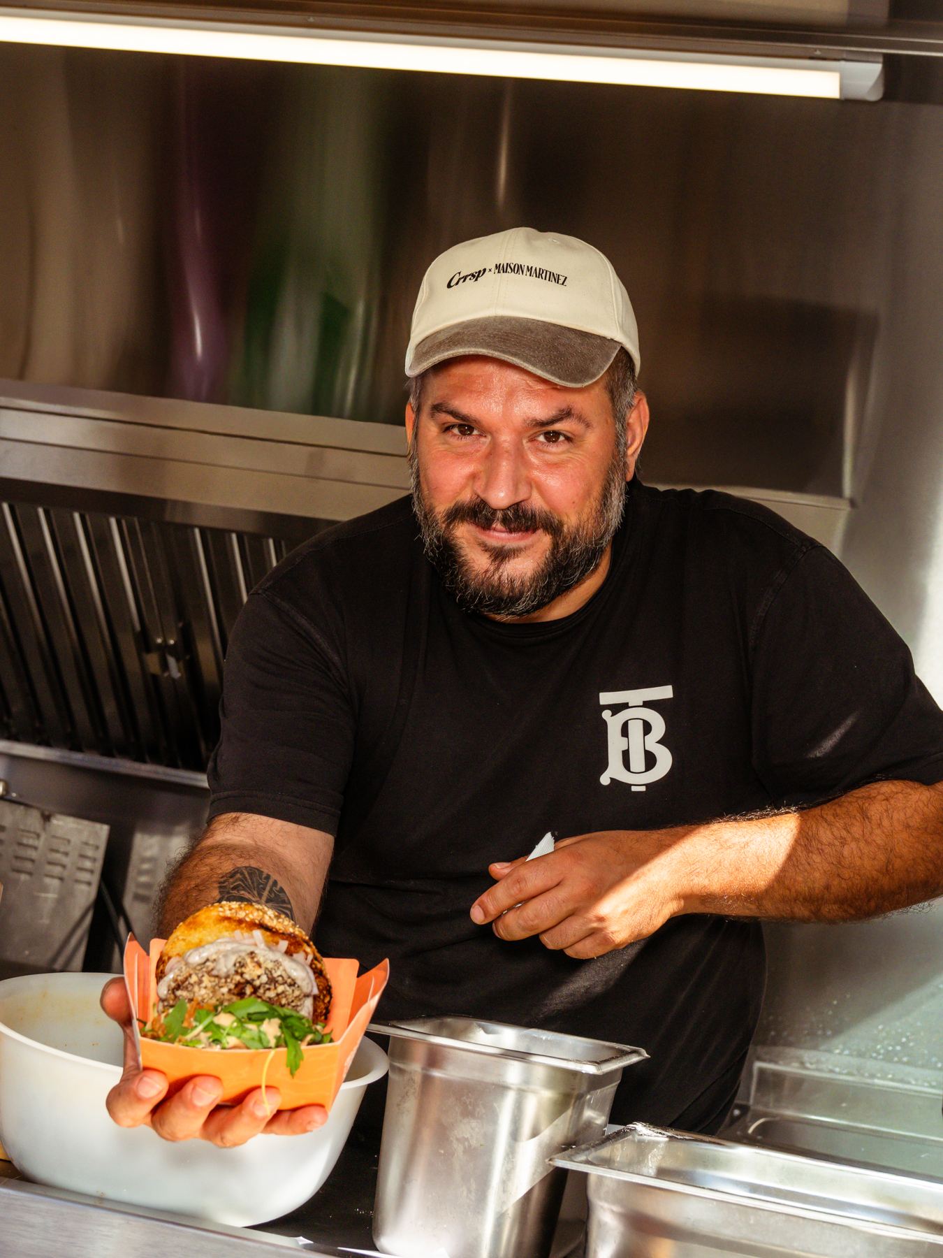 Un cuoco presenta un piatto nel proprio rimorchio food truck